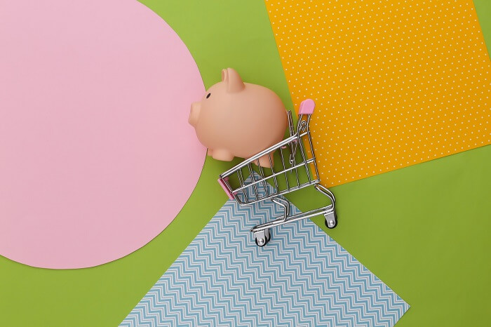 shopping-trolley-with-piggy-bank-creative-colorful-paper-background