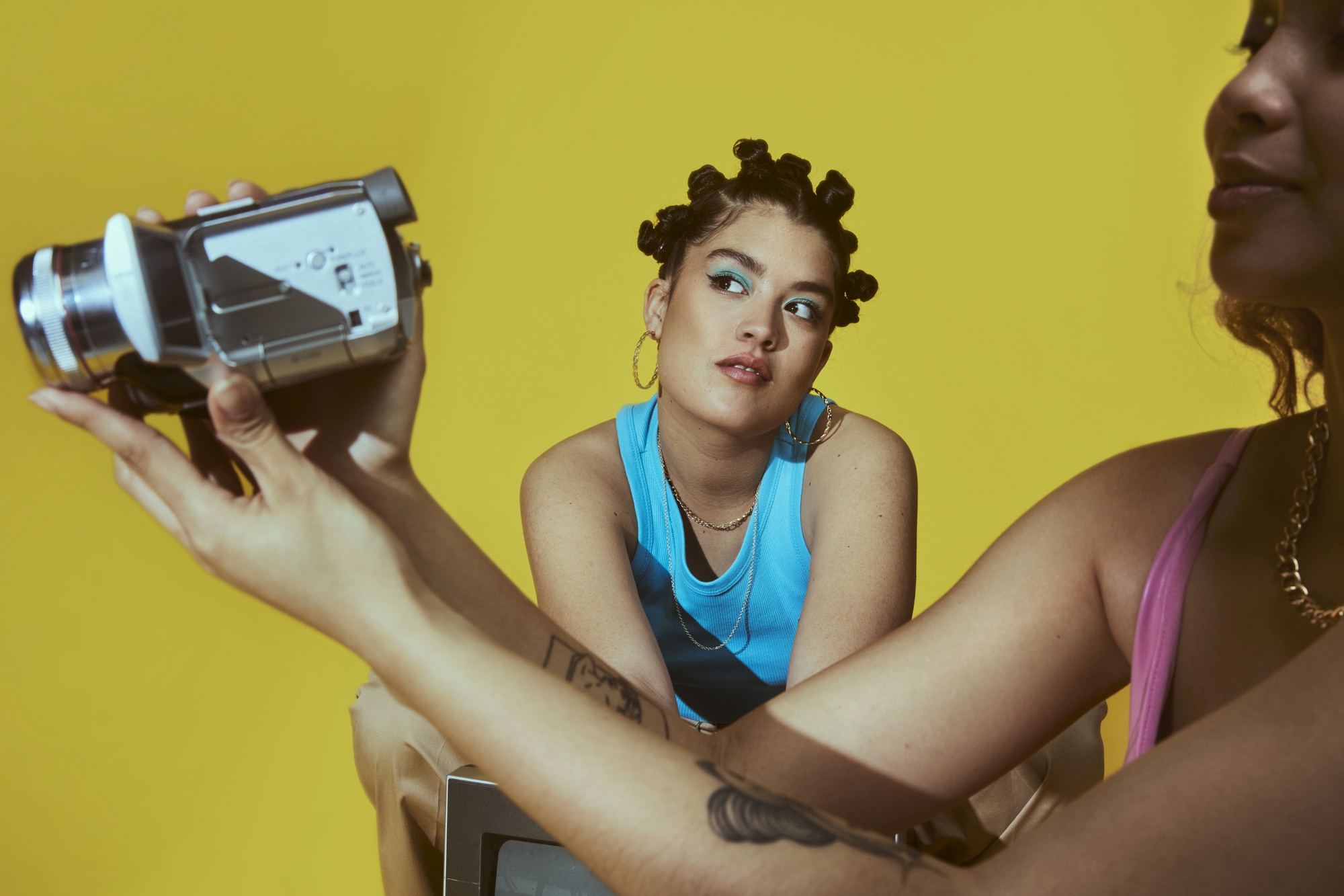 two-girls-doing-videography-in-a-yellow-background