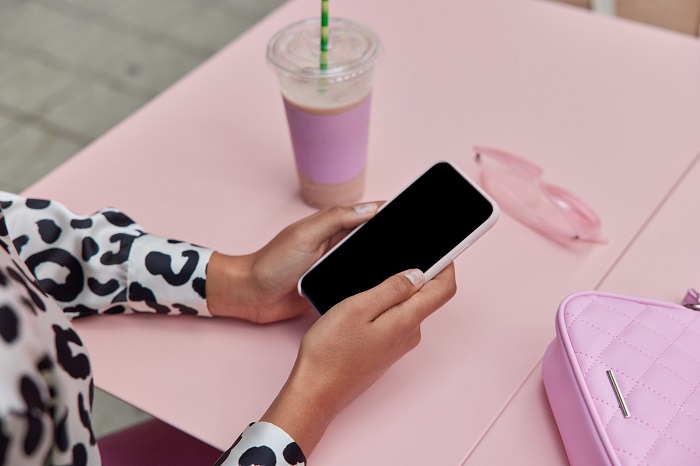 woman-hands-holding-smart-phone-at-a-coffee-shop