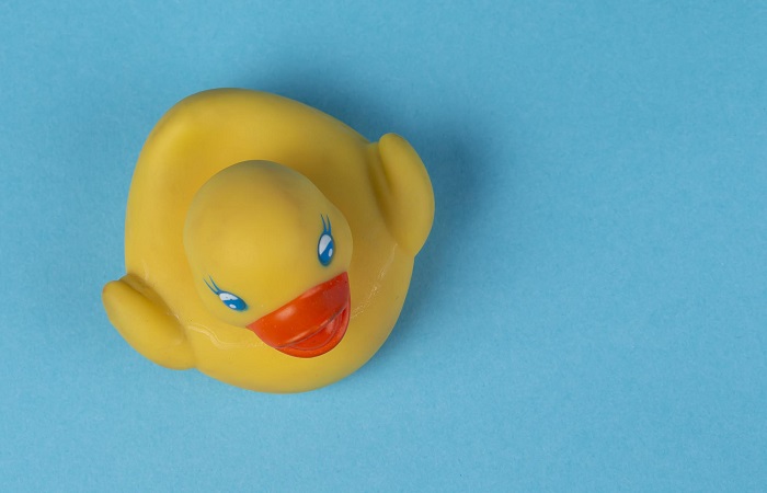 yellow-rubber-duck-swimming-blue-background