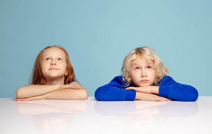 two boy and girl kids wearing blue and bright clothes affected by gender marketing